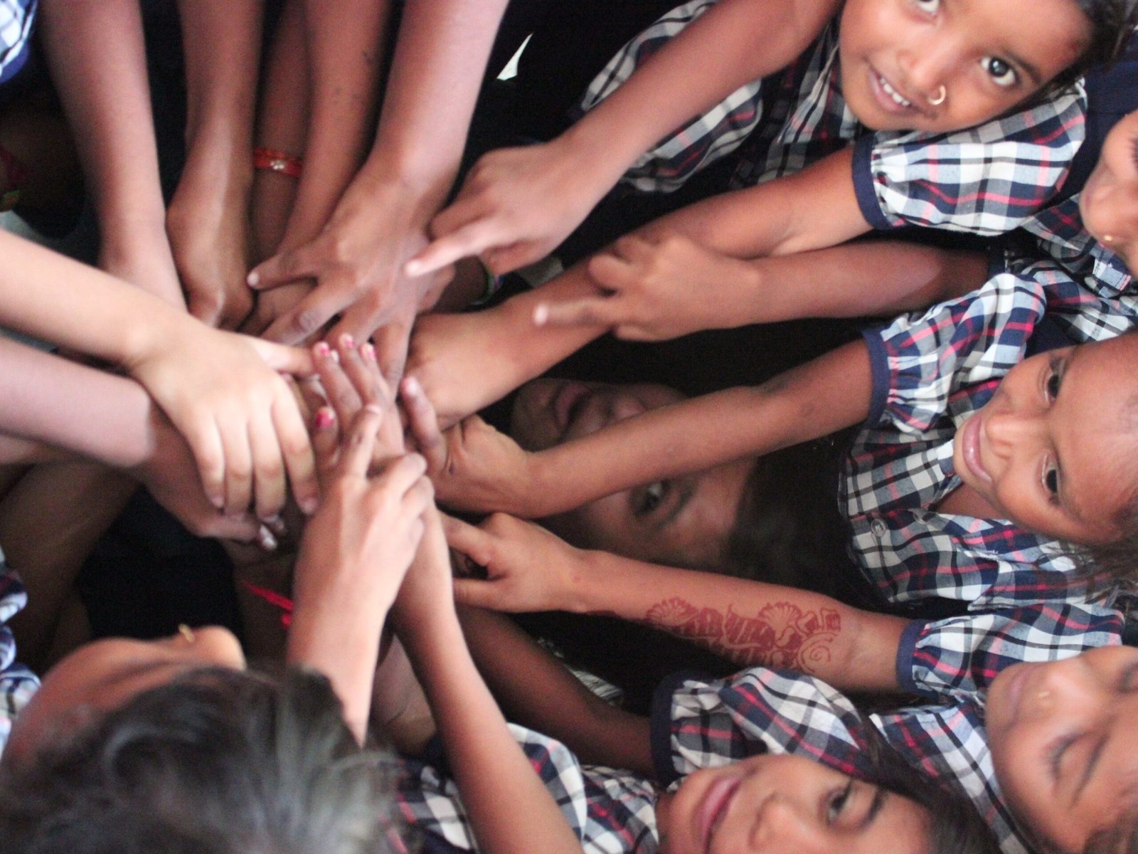image of students of vasad's school engaged in an activity of putting hands on each other captured by Jainish Soni