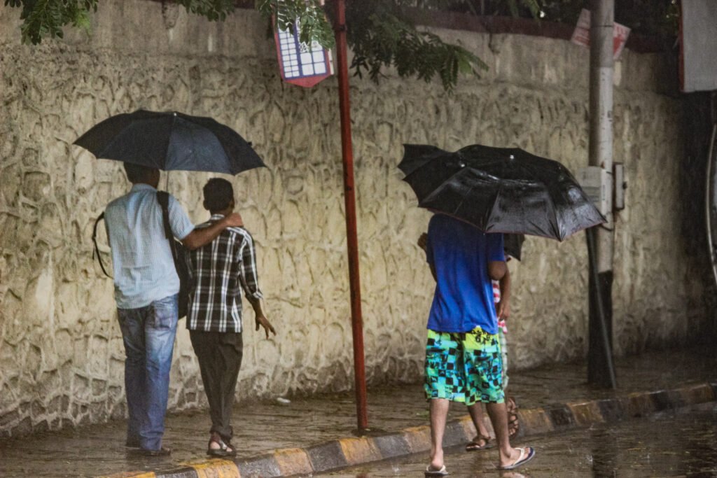 image of people walking with umbrellas on the streets of Mumbai captured by Jainish Soni