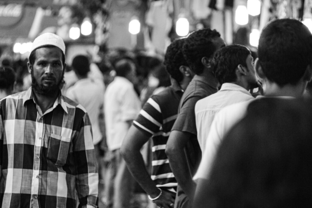 black and white image of a man walking on the street captured by Jainish Soni